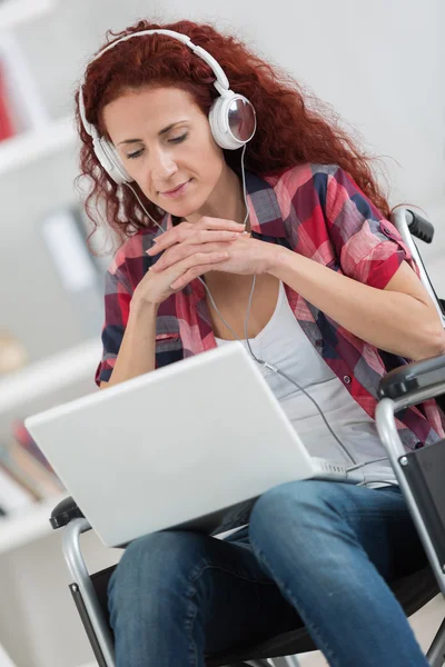 Gelukkig volwassen gehandicapte vrouw met laptop binnen — Stockfoto
