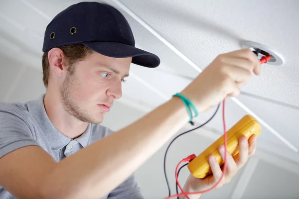 Homme vérifiant la source d'électricité — Photo