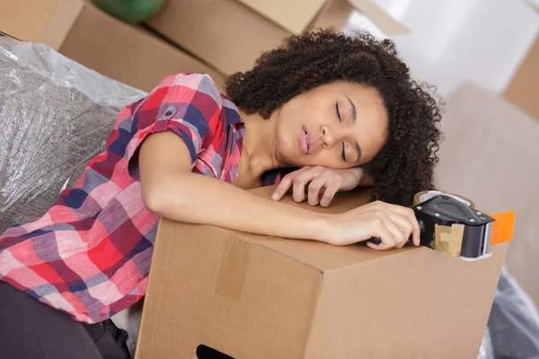 Жінка спить на картонній коробці — стокове фото