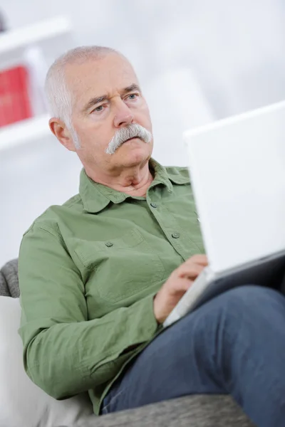 Старший чоловік працює на портативному комп'ютері — стокове фото