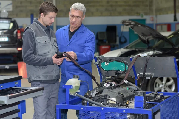 Onderwijzer en student in auto mechanica opleiding klasse — Stockfoto