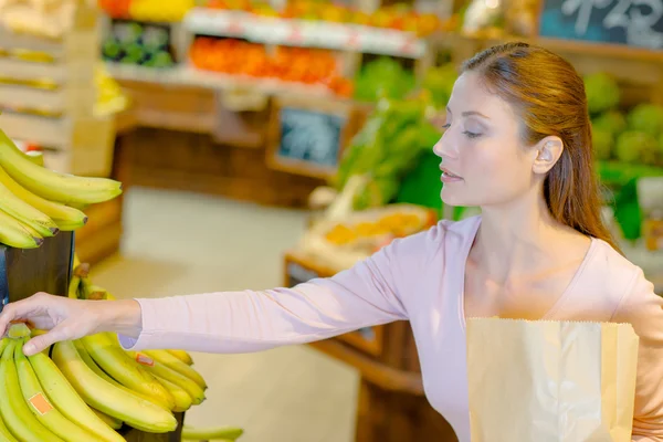 Senhora comprando bananas e maçãs — Fotografia de Stock