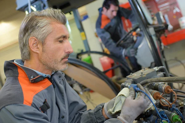 Twee monteurs werken in garage — Stockfoto