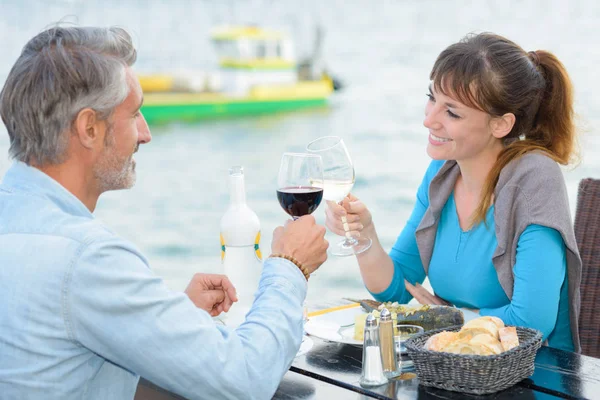 Paar prostet sich im Restaurant am Fluss zu — Stockfoto