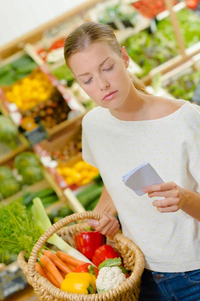 Mulher verificando sua lista de compras — Fotografia de Stock