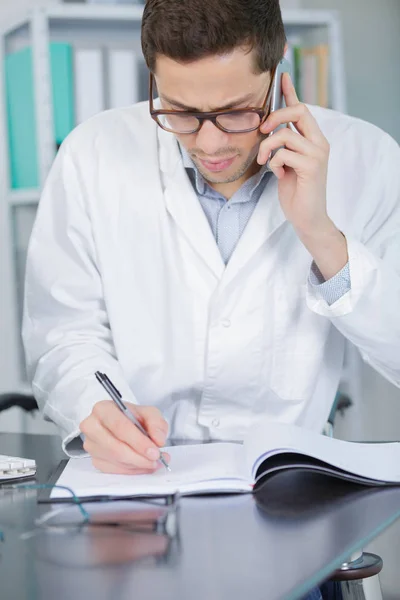 Mladý chemik na telefonu v laboratoři — Stock fotografie