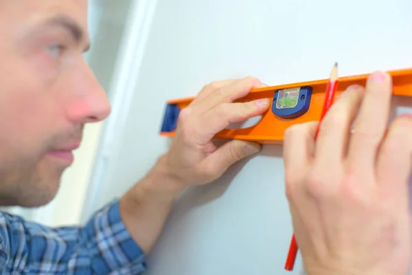 Using a spirit level to check a wall is straight — Stock Photo, Image