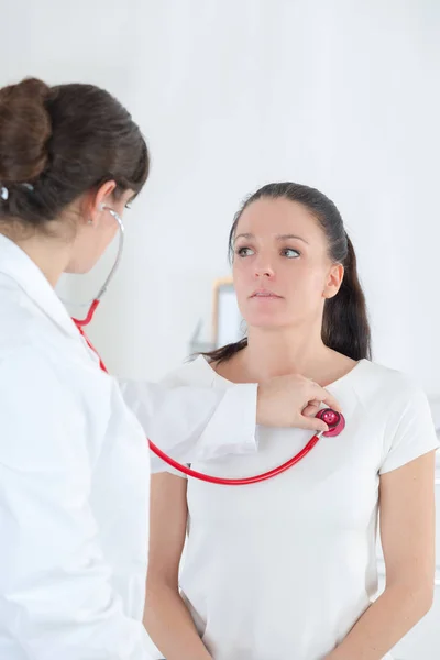 Mujer médico auscultar paciente con estetoscopio —  Fotos de Stock