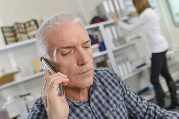 Senior office worker taking an important call — Stock Photo, Image