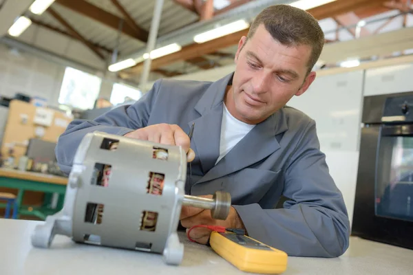 Mechanik praca na cylindrycznych komponentów elektrycznych — Zdjęcie stockowe