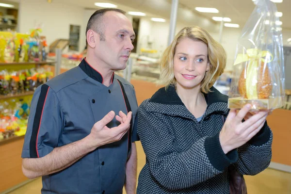 Personale di pasticceria positivo che offre pasticcini in vendita — Foto Stock