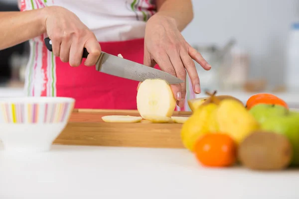 Close-up op volwassen vrouwtje handen snijden appels op hakken bestuur — Stockfoto