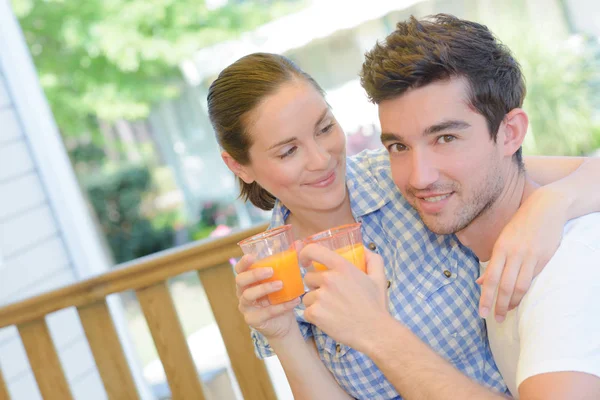 Amorous couple with glasses of juice — Stock Photo, Image