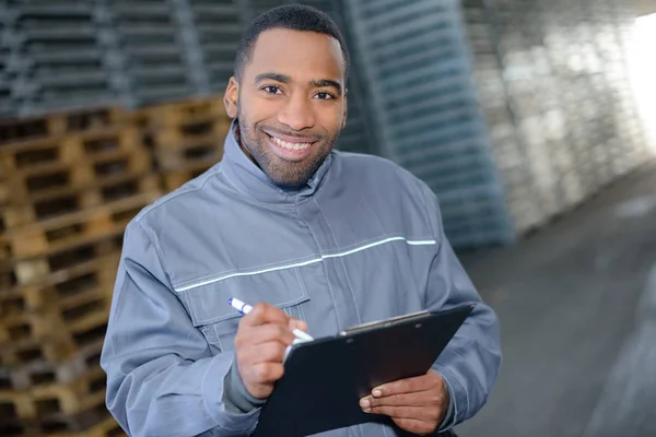 Warehouse worker holding a document — Stock Photo, Image