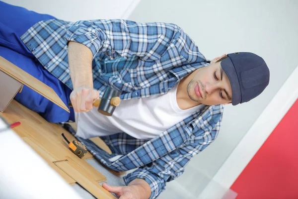 Épület javítási és otthoni fogalom - férfi mérő fa padlóburkolatok — Stock Fotó