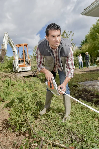 Jardineiro tomando medidas e precisas — Fotografia de Stock