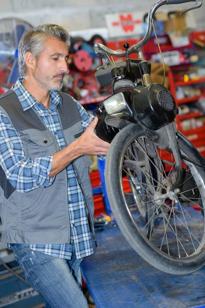 Mechanic working on motorised bicycle — Stock Photo, Image
