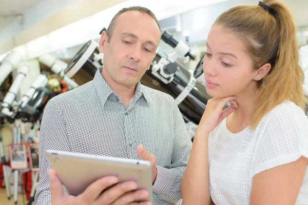 Hombre y joven dama mirando tableta — Foto de Stock