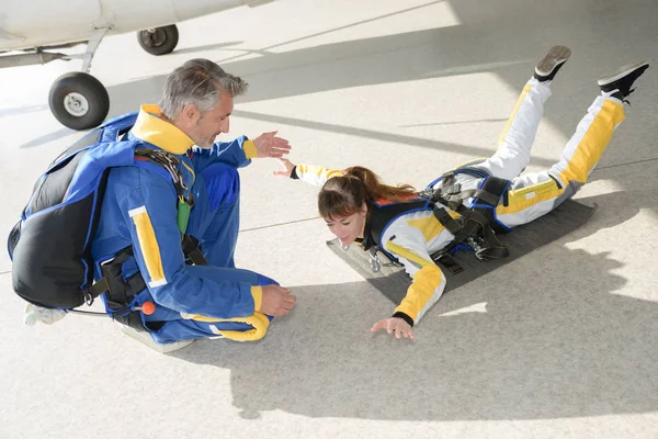 Vrouw beoefenen van parachutespringen houding — Stockfoto