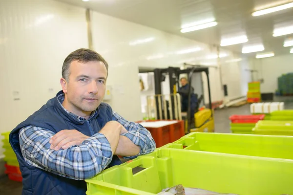 Porträt eines Mannes, der sich an eine Fischkiste lehnt — Stockfoto