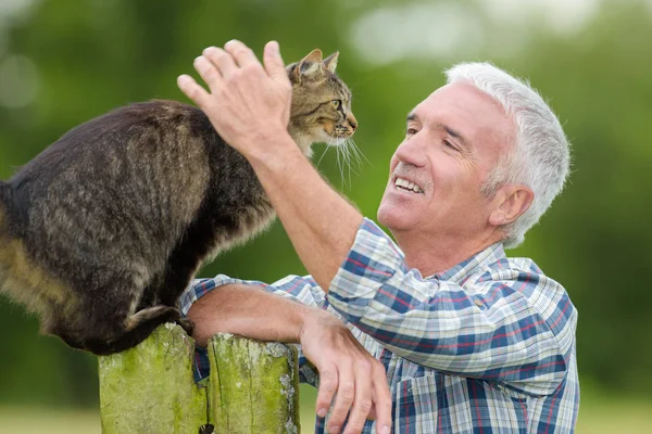 Mann streichelt Katze und streichelt sie — Stockfoto