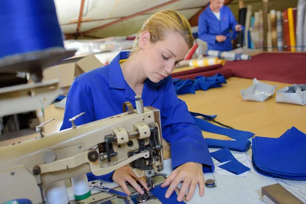 Женщина с помощью промышленной швейной машины — стоковое фото
