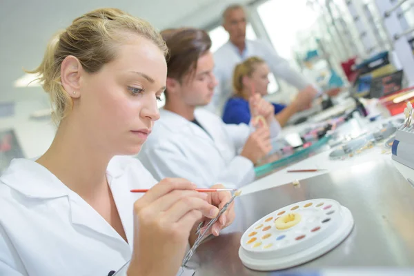 Técnico femenino trabajando en un laboratorio de prótesis dentales — Foto de Stock