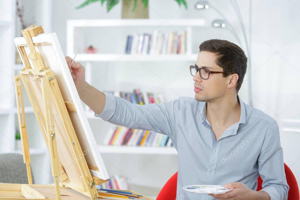 Young painter drawing on a canvas — Stock Photo © photography33 129746124