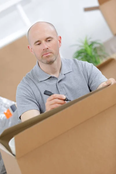 Junger Mann beim Packen von Kartons — Stockfoto