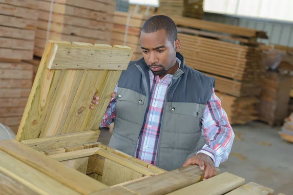 Trabajador junto a caja de madera abierta — Foto de Stock