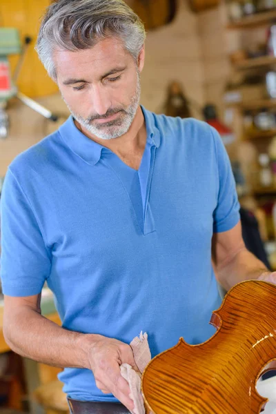 Luthier limpando um violino — Fotografia de Stock