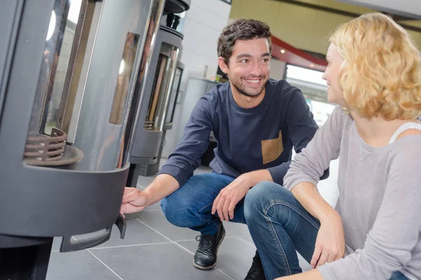 Couple looking at display of woodburners — Stock Photo, Image