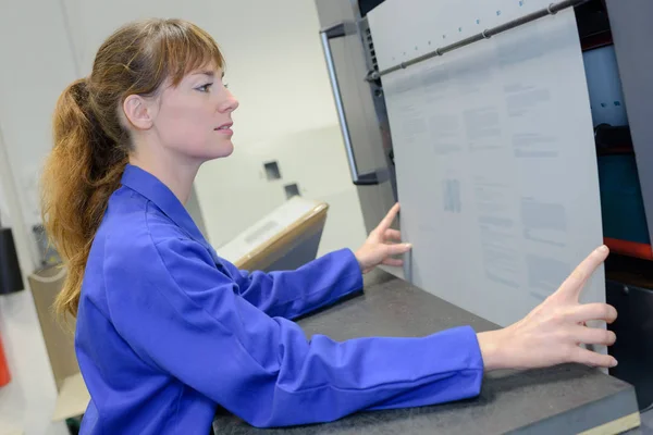 Werkneemster strekken van de kaart in de machine — Stockfoto