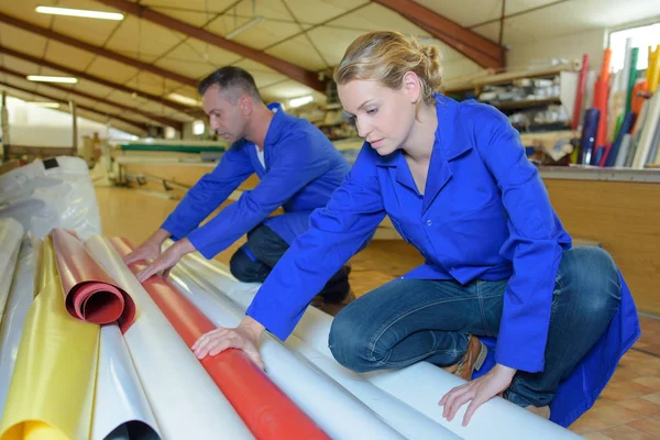 Hombre y mujer eligiendo rollo de material — Foto de Stock