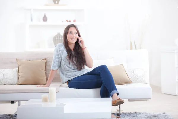 Talking a call whilst on the sofa — Stock Photo, Image