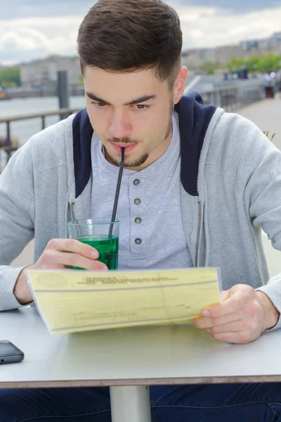 Jonge kerel met een drinkat de bar — Stockfoto