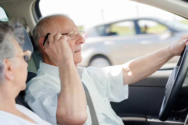 Anciano usando el teléfono móvil mientras conduce — Foto de Stock