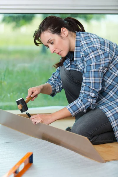 Bonita mujer usando un martillo para bricolaje en casa —  Fotos de Stock