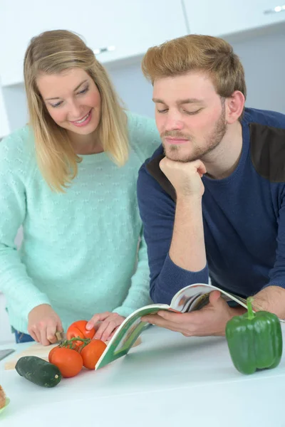 Jovem casal na cozinha preparando o almoço — Fotografia de Stock