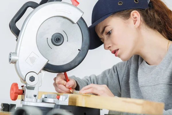 Ženské carpenter označení na dřevě s tužkou v dílně — Stock fotografie