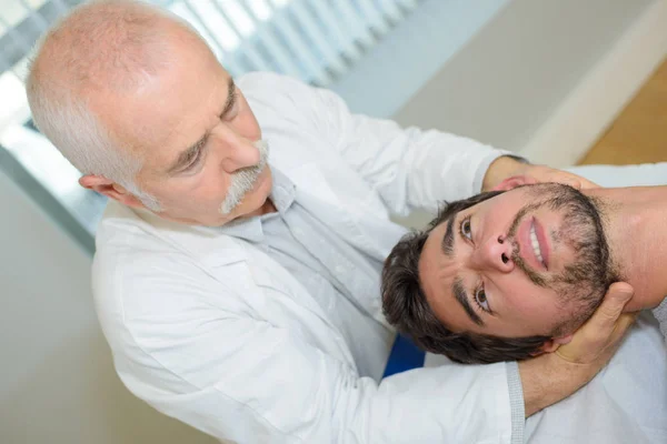 Homem recebendo massagem na cabeça em consultório médico — Fotografia de Stock