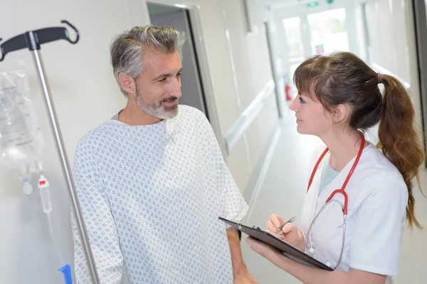 Medico donna che interagisce con la paziente nel corridoio ospedaliero — Foto Stock