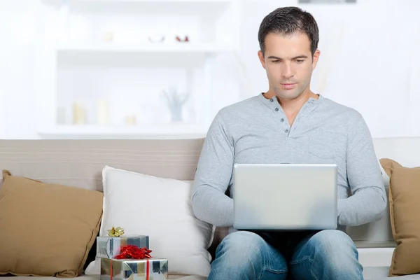 Glücklicher Mann sitzt mit Laptop-Computer auf Sofa — Stockfoto