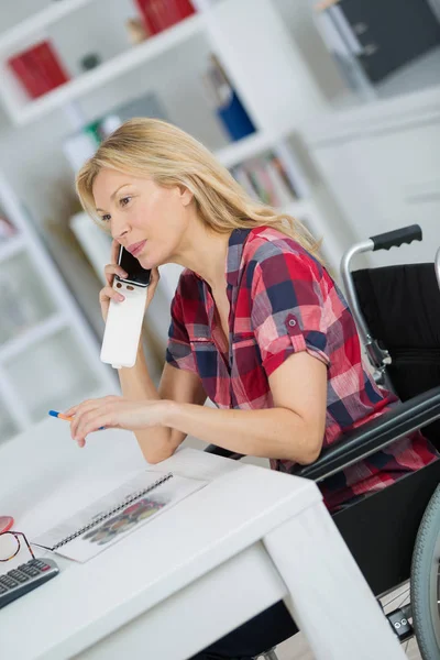 Behinderte Frau im Rollstuhl telefoniert professionell — Stockfoto