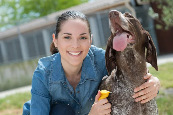 Veterinário fêmea acariciando cão no abrigo animal — Fotografia de Stock