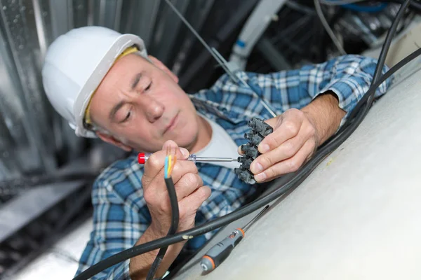 Elektrikář elektroinstalace uvnitř stropu příslušného — Stock fotografie