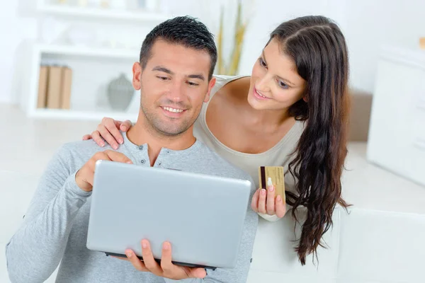 Joven pareja guapo mirando en el ordenador portátil en casa — Foto de Stock