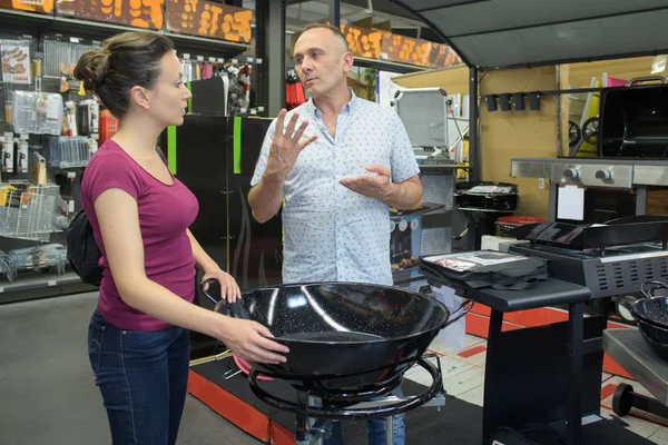 Casal falando sobre o preço de um churrasco — Fotografia de Stock