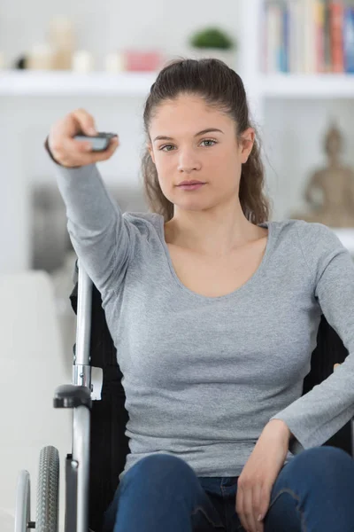 Disabled woman in wheelchair watching movies at home — Stock Photo, Image