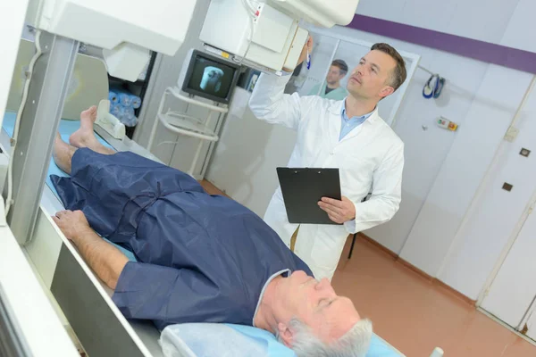 Médico masculino confiante no hospital com paciente submetido à ressonância magnética — Fotografia de Stock